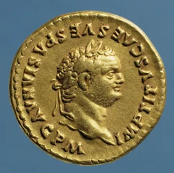 Aureus (avers) de Titus (79-81 après J.-C.) portant une couronne de laurier. Inscription : IMP TITVS CAES VESPASIAN AVG P M